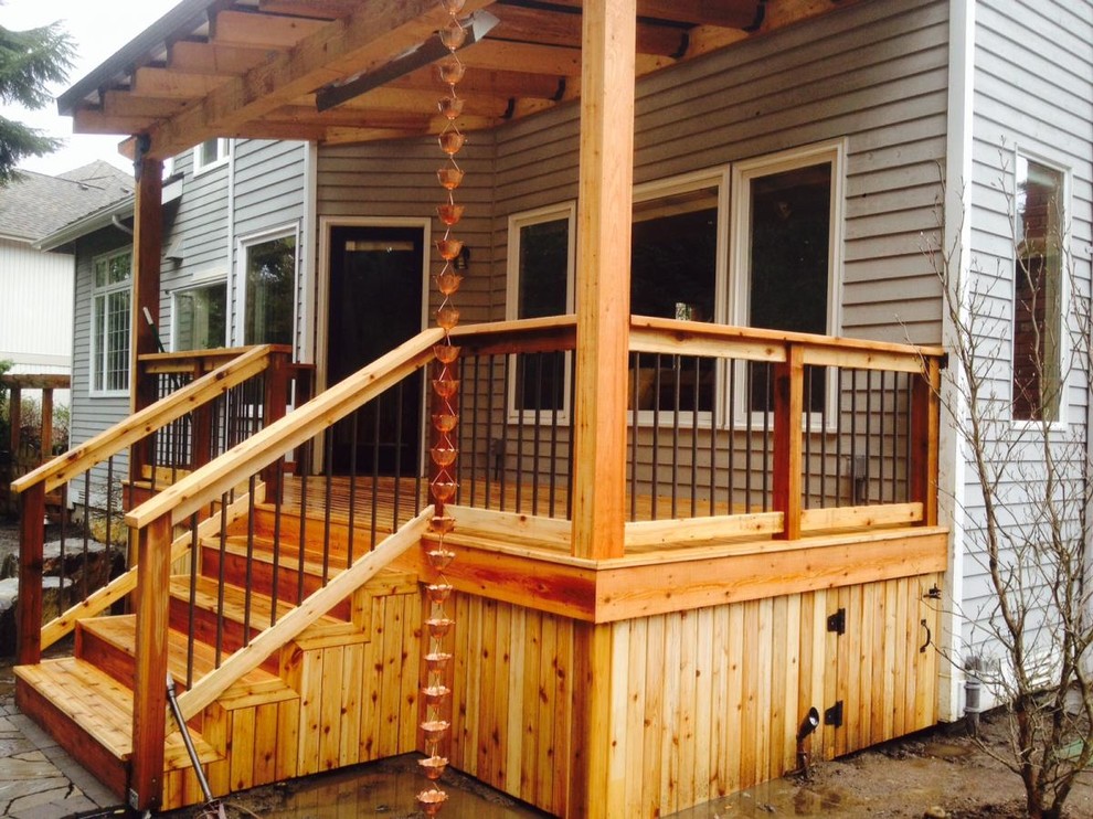 Design ideas for a small arts and crafts backyard deck in Seattle with a pergola.