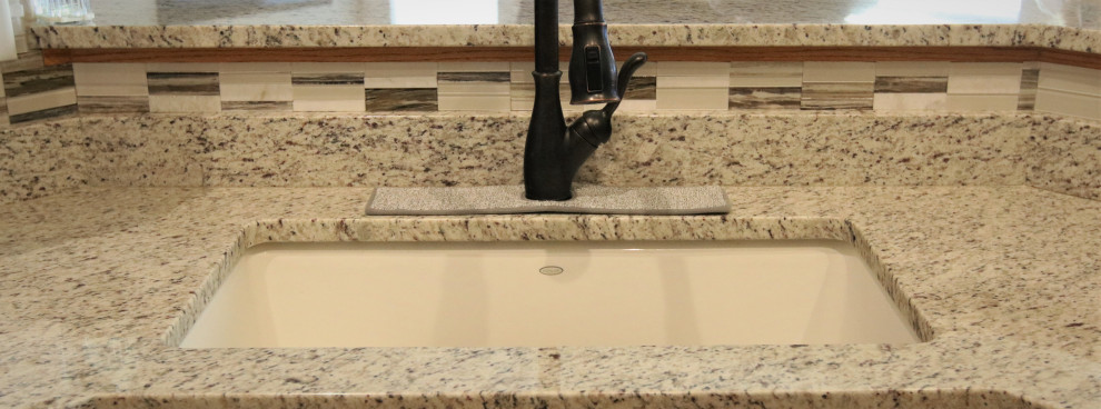 Small eat-in kitchen photo with granite countertops, multicolored backsplash, mosaic tile backsplash and multicolored countertops