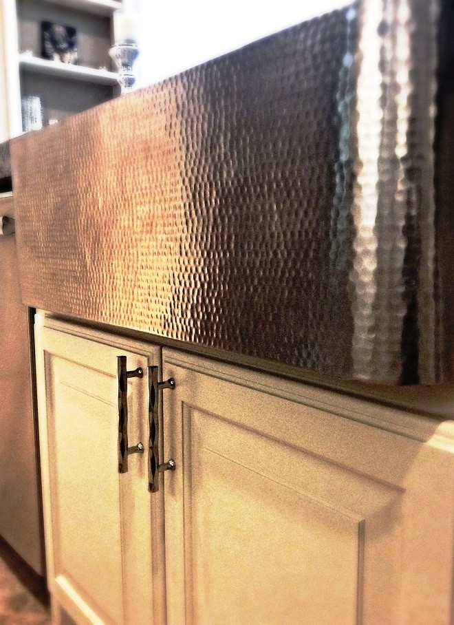 Mid-sized transitional l-shaped travertine floor eat-in kitchen photo in Houston with a farmhouse sink, raised-panel cabinets, white cabinets, granite countertops, metallic backsplash, metal backsplash, stainless steel appliances and an island