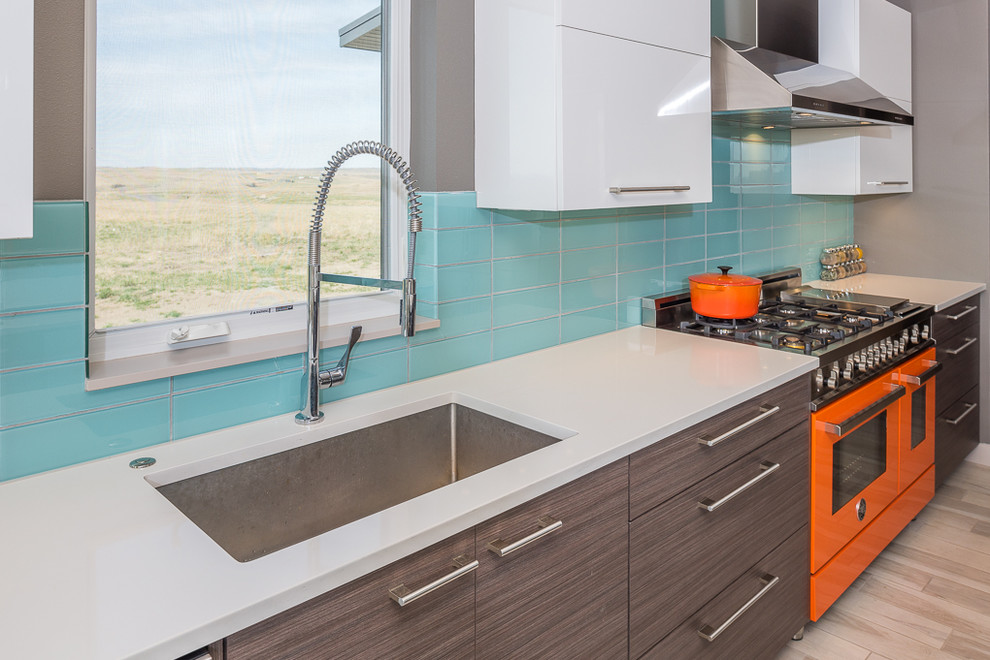 Large modern l-shaped eat-in kitchen in Other with a single-bowl sink, flat-panel cabinets, dark wood cabinets, quartzite benchtops, green splashback, glass tile splashback, coloured appliances, ceramic floors and with island.