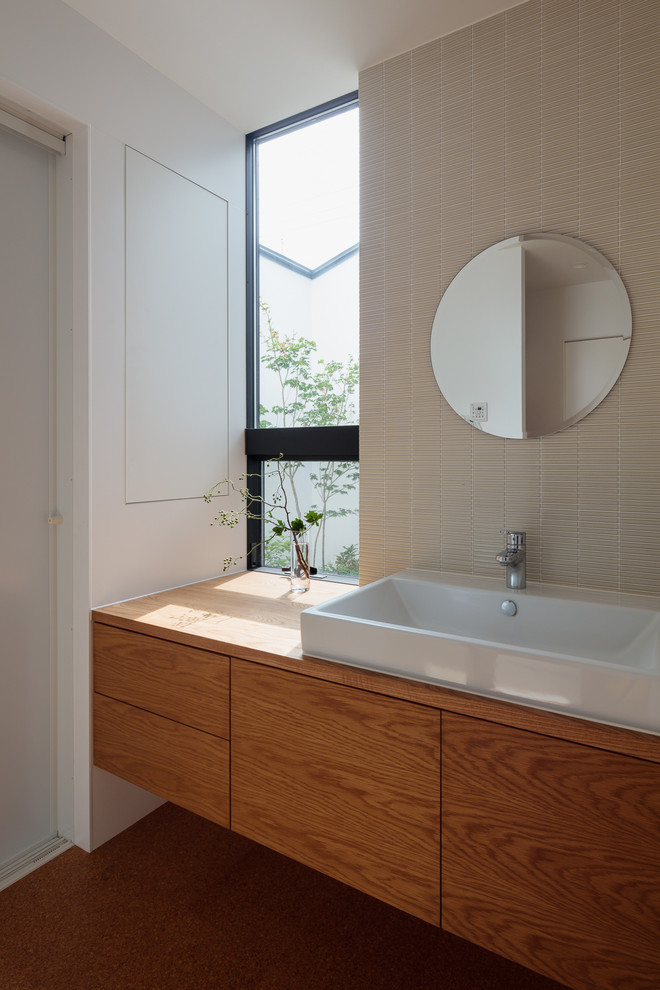 Contemporary bathroom in Other with flat-panel cabinets, medium wood cabinets, beige tile, mosaic tile, white walls, a vessel sink, wood benchtops, brown floor and brown benchtops.