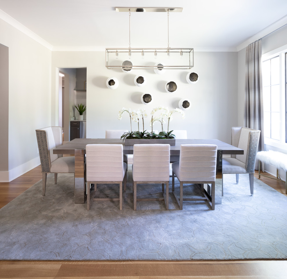 Transitional medium tone wood floor and brown floor dining room photo with white walls and no fireplace