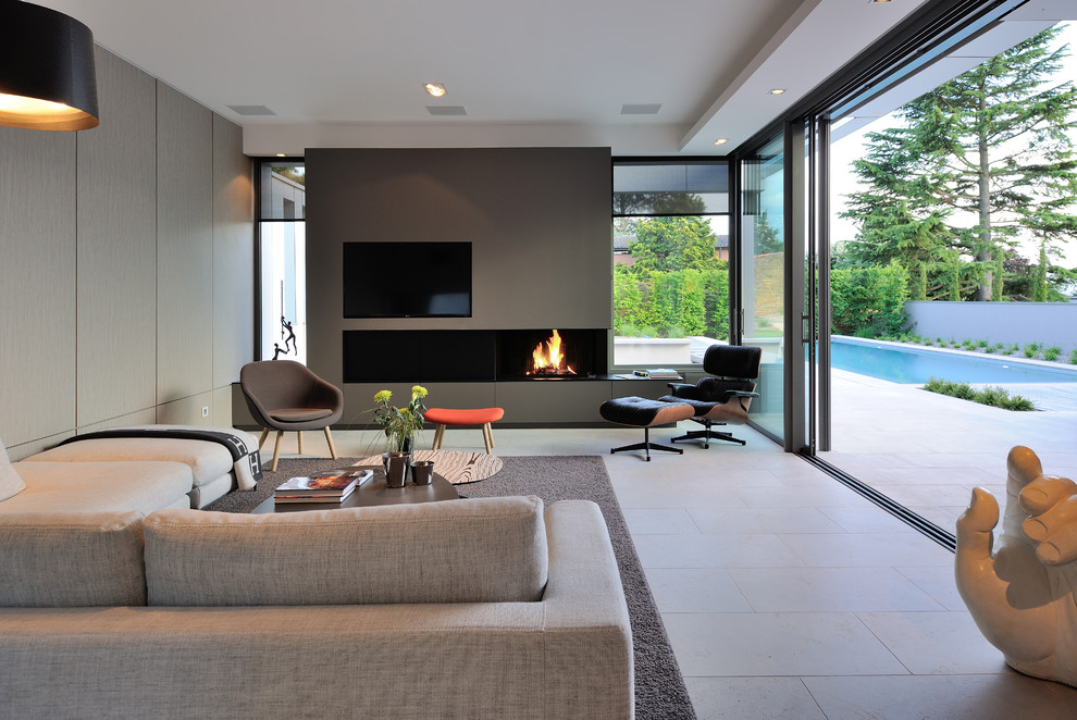 This is an example of a large contemporary enclosed family room in Lyon with grey walls, a ribbon fireplace and a built-in media wall.