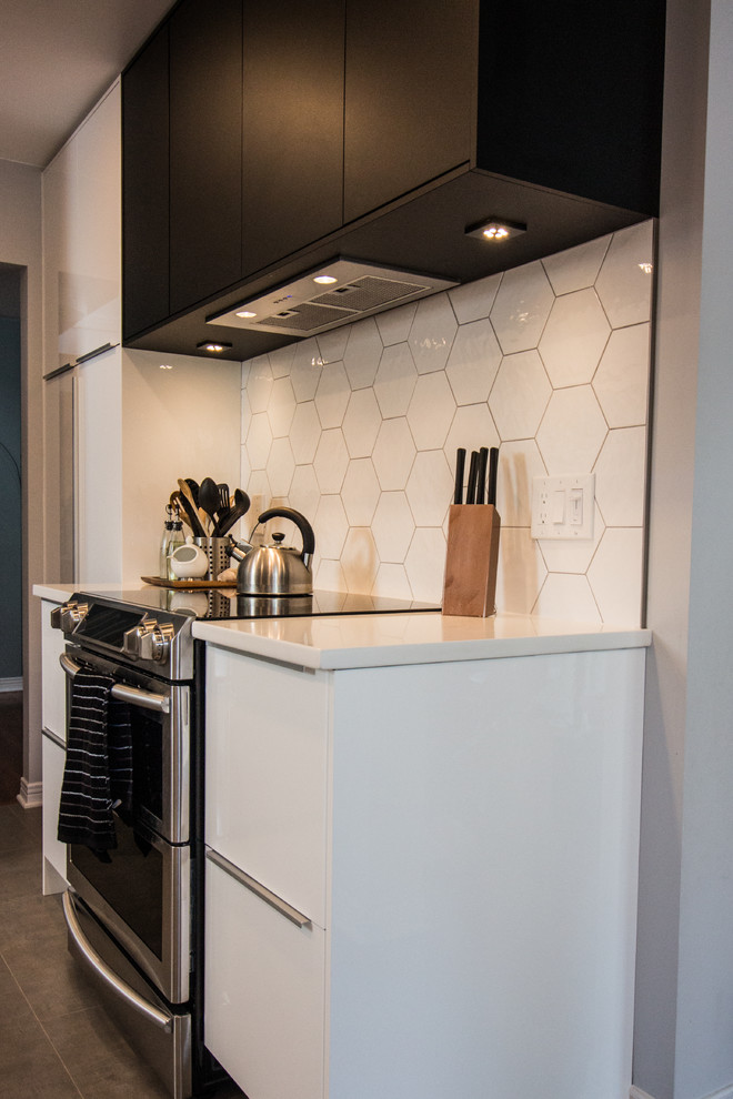 This is an example of a mid-sized scandinavian u-shaped eat-in kitchen in Ottawa with an undermount sink, flat-panel cabinets, white cabinets, quartz benchtops, white splashback, ceramic splashback, stainless steel appliances, porcelain floors, a peninsula and grey floor.