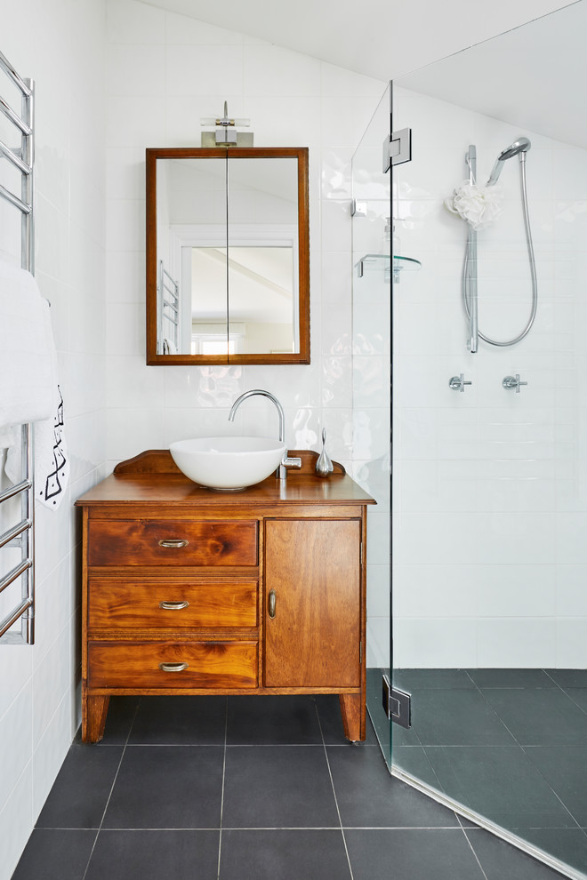 Inspiration for a small transitional master bathroom in Sydney with medium wood cabinets, a corner shower, white tile, white walls, a vessel sink, black floor, a hinged shower door, a one-piece toilet, porcelain tile, porcelain floors, wood benchtops, brown benchtops and flat-panel cabinets.