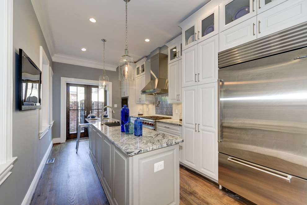 Inspiration for a mid-sized transitional galley separate kitchen in DC Metro with a single-bowl sink, raised-panel cabinets, white cabinets, granite benchtops, white splashback, glass tile splashback, stainless steel appliances, dark hardwood floors, with island and brown floor.