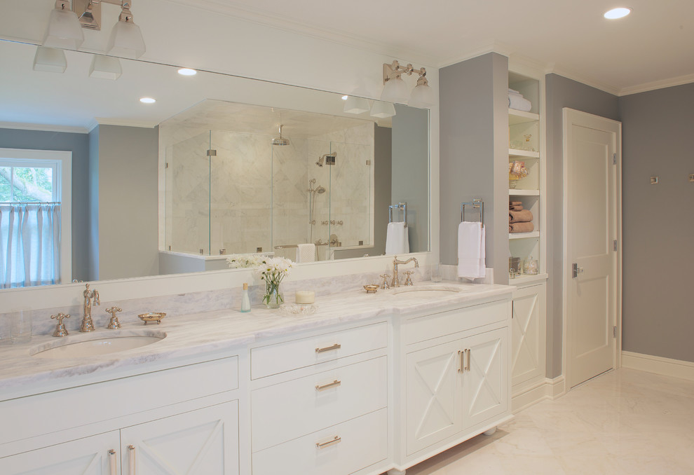 Photo of a large transitional master bathroom in DC Metro with white cabinets, gray tile, stone tile, grey walls, an undermount sink, marble benchtops, furniture-like cabinets, a corner shower, marble floors, white floor and a hinged shower door.