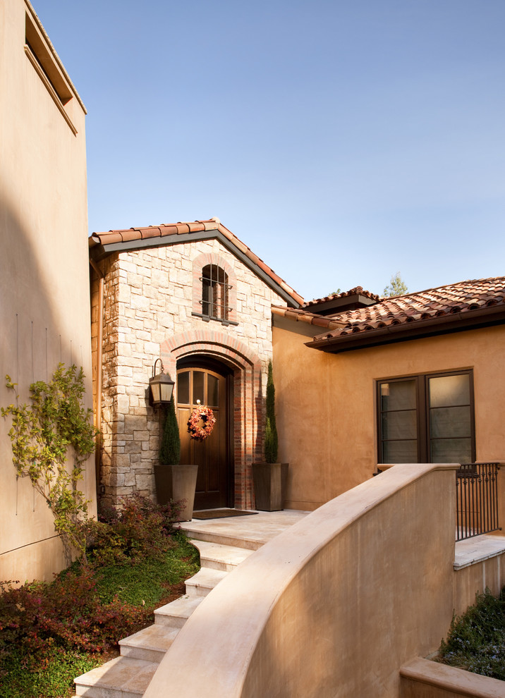 Large mediterranean one-storey stucco beige exterior in San Francisco with a gable roof.