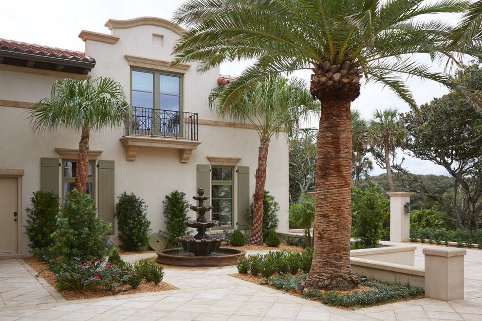 Photo of a large mediterranean two-storey stucco beige house exterior in Jacksonville with a hip roof and a shingle roof.