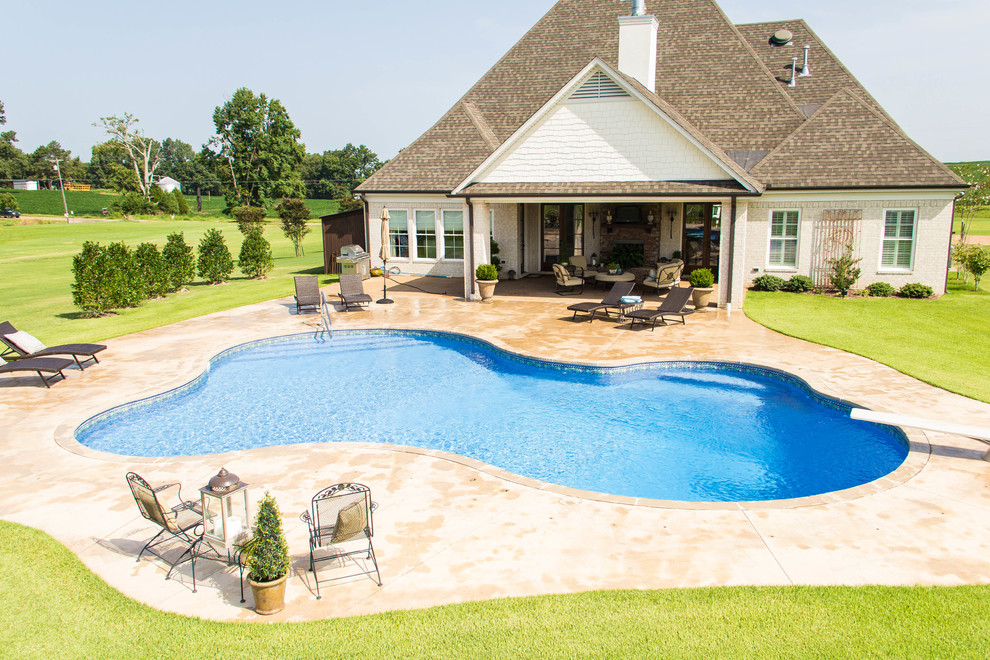 Photo of a large traditional backyard custom-shaped pool in Chicago with stamped concrete.