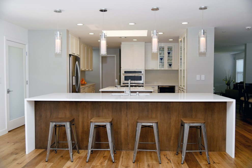 Example of a large transitional eat-in kitchen design in Los Angeles with an undermount sink, shaker cabinets, quartz countertops, stainless steel appliances and two islands
