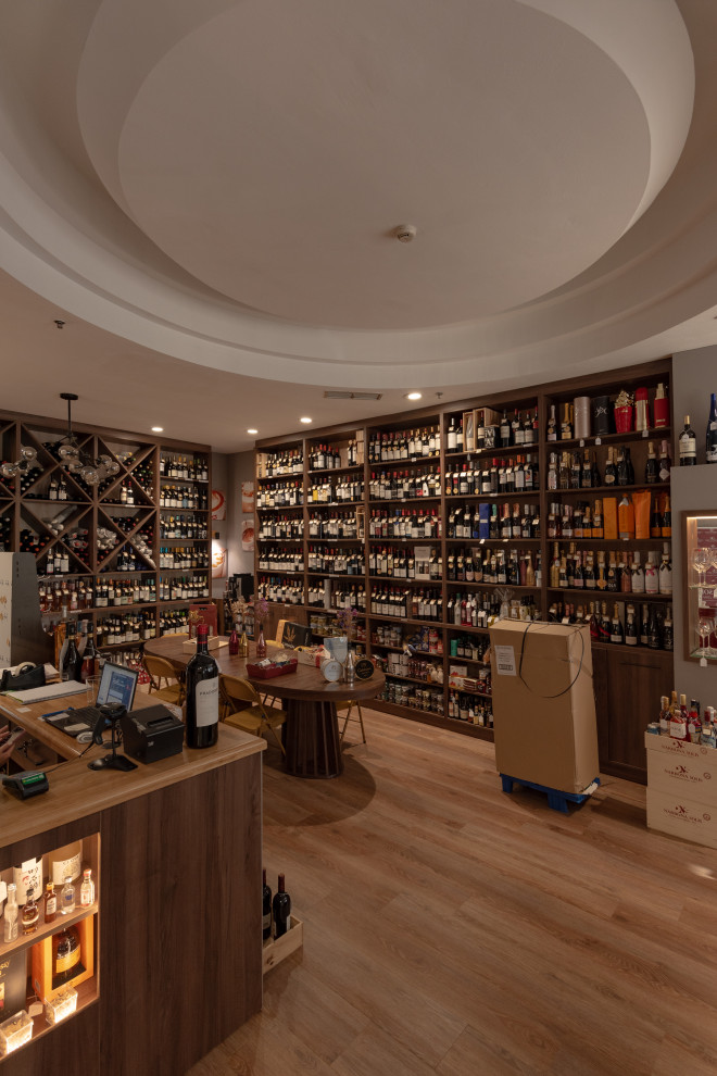 Inspiration for a small transitional wine cellar in Malaga with plywood floors, display racks and brown floor.