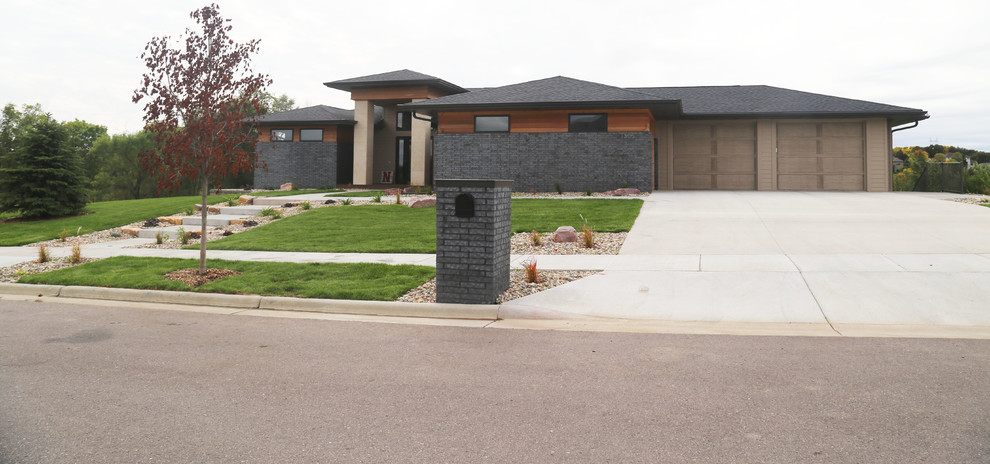 Home design - large transitional two-story brick gray home design idea with a hip roof