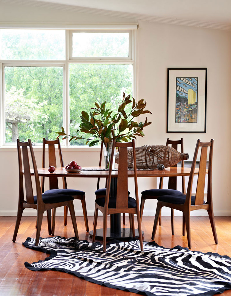Photo of an eclectic dining room in Melbourne with white walls, medium hardwood floors and no fireplace.