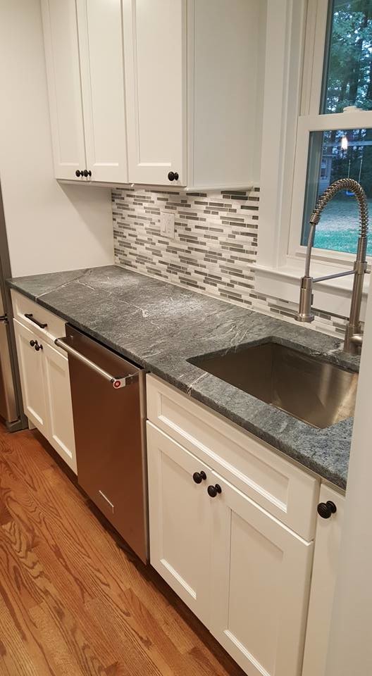 Large transitional l-shaped medium tone wood floor open concept kitchen photo in Baltimore with shaker cabinets, white cabinets, an island, soapstone countertops, multicolored backsplash, matchstick tile backsplash and stainless steel appliances