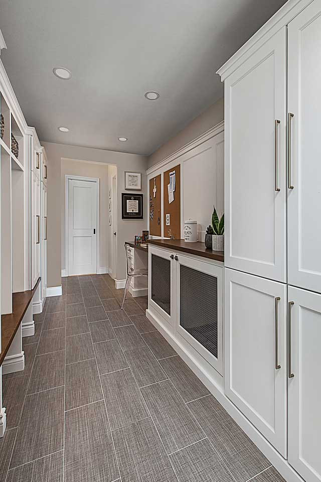 Inspiration for a large transitional galley porcelain tile, beige floor and wall paneling utility room remodel in Detroit with an undermount sink, recessed-panel cabinets, white cabinets, quartz countertops, gray walls, a side-by-side washer/dryer, beige countertops, white backsplash and wood backsplash