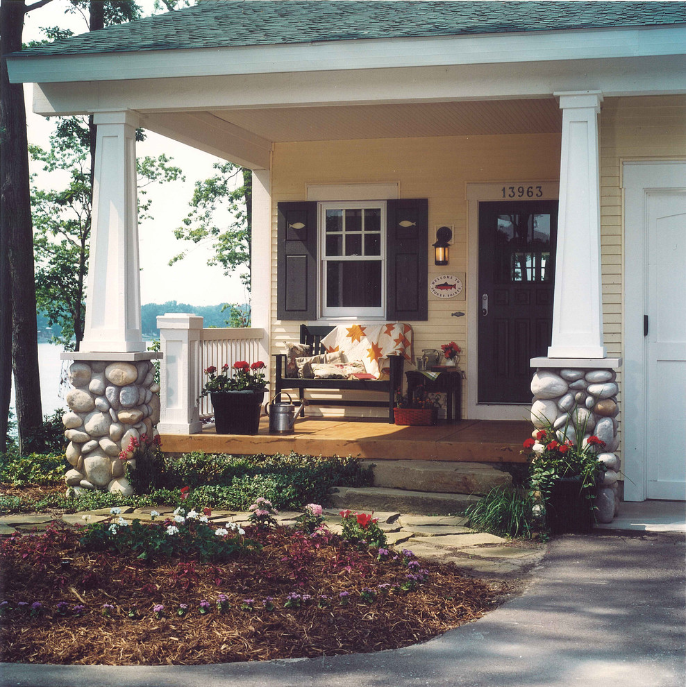 Photo of a traditional front yard verandah in Grand Rapids with a roof extension.
