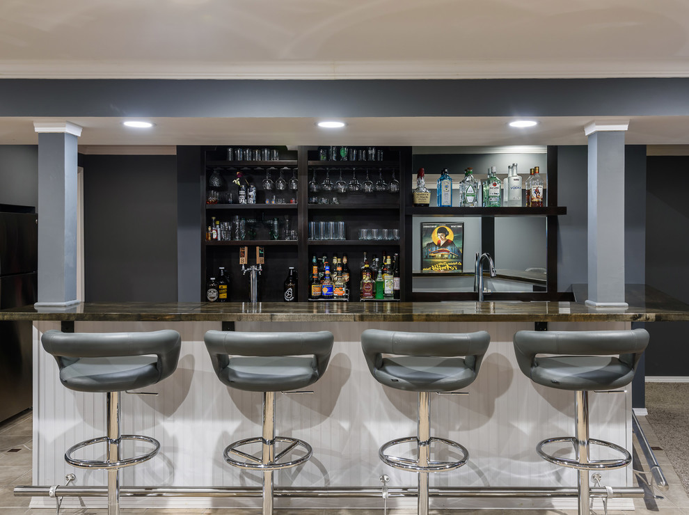 Inspiration for a mid-sized modern single-wall seated home bar in St Louis with a drop-in sink, open cabinets, black cabinets, wood benchtops, mirror splashback, carpet, beige floor and brown benchtop.