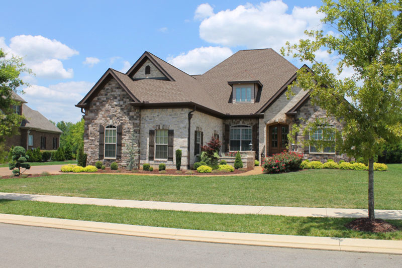 This is an example of a large traditional two-storey brick brown exterior in Nashville with a gable roof.