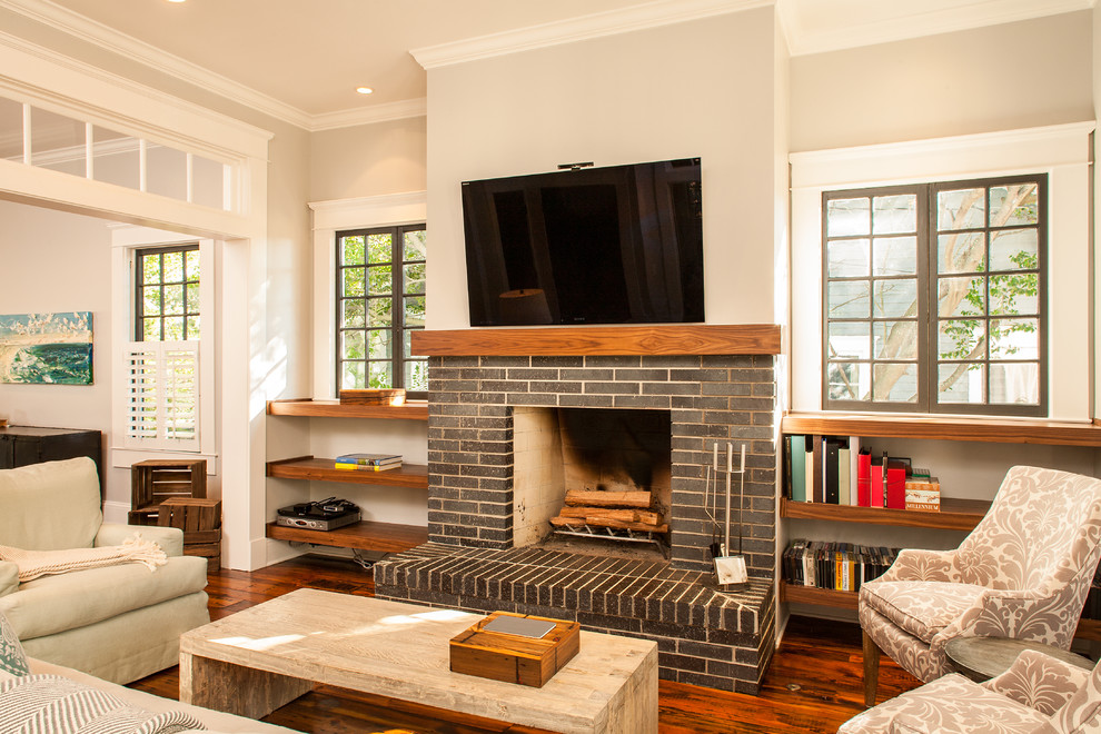 This is an example of an arts and crafts enclosed living room in Atlanta with a standard fireplace and a wall-mounted tv.