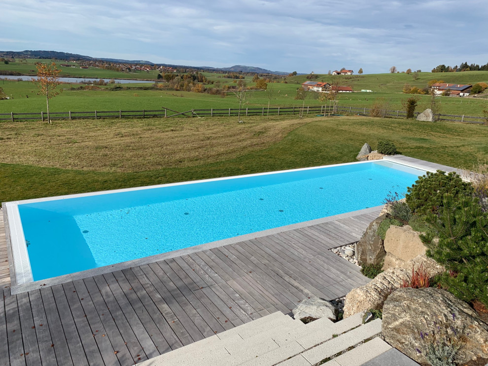 Foto di una grande piscina a sfioro infinito minimalista rettangolare con piastrelle