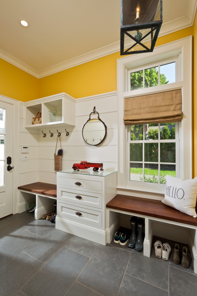 Large traditional boot room in New York with yellow walls, slate flooring, a single front door, a white front door, grey floors and tongue and groove walls.