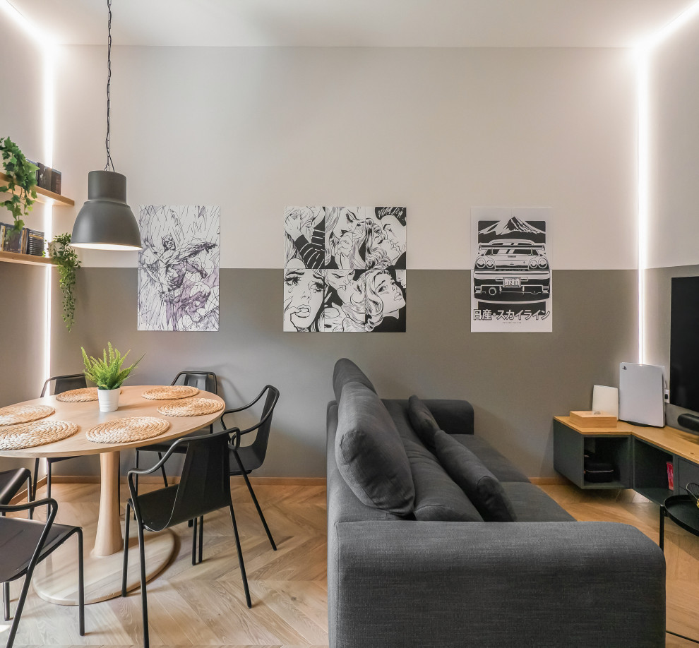 Foto di un piccolo soggiorno industriale aperto con pareti grigie, parquet chiaro, TV a parete e soffitto ribassato