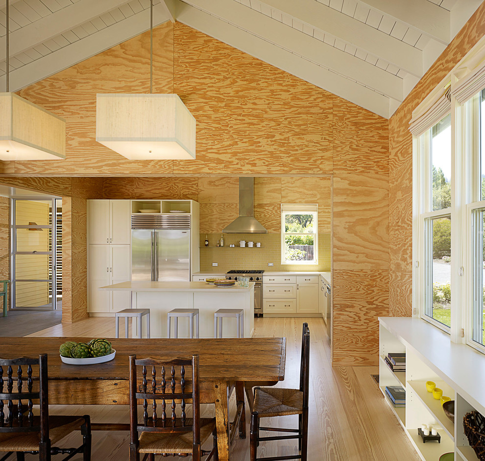 Country l-shaped eat-in kitchen in San Francisco with yellow splashback and stainless steel appliances.