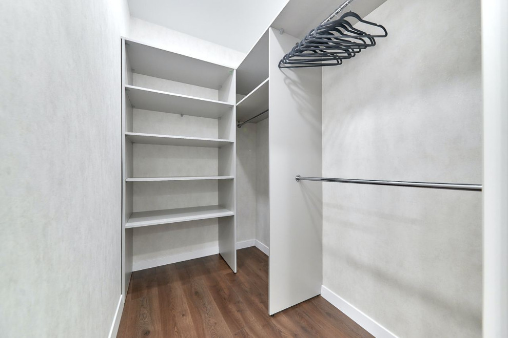 Idee per una cabina armadio unisex minimal di medie dimensioni con nessun'anta, ante in legno chiaro, pavimento in laminato e pavimento marrone