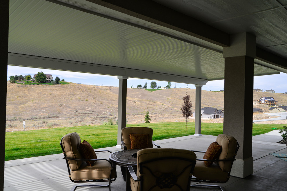 Large transitional backyard patio photo in Boise with a roof extension