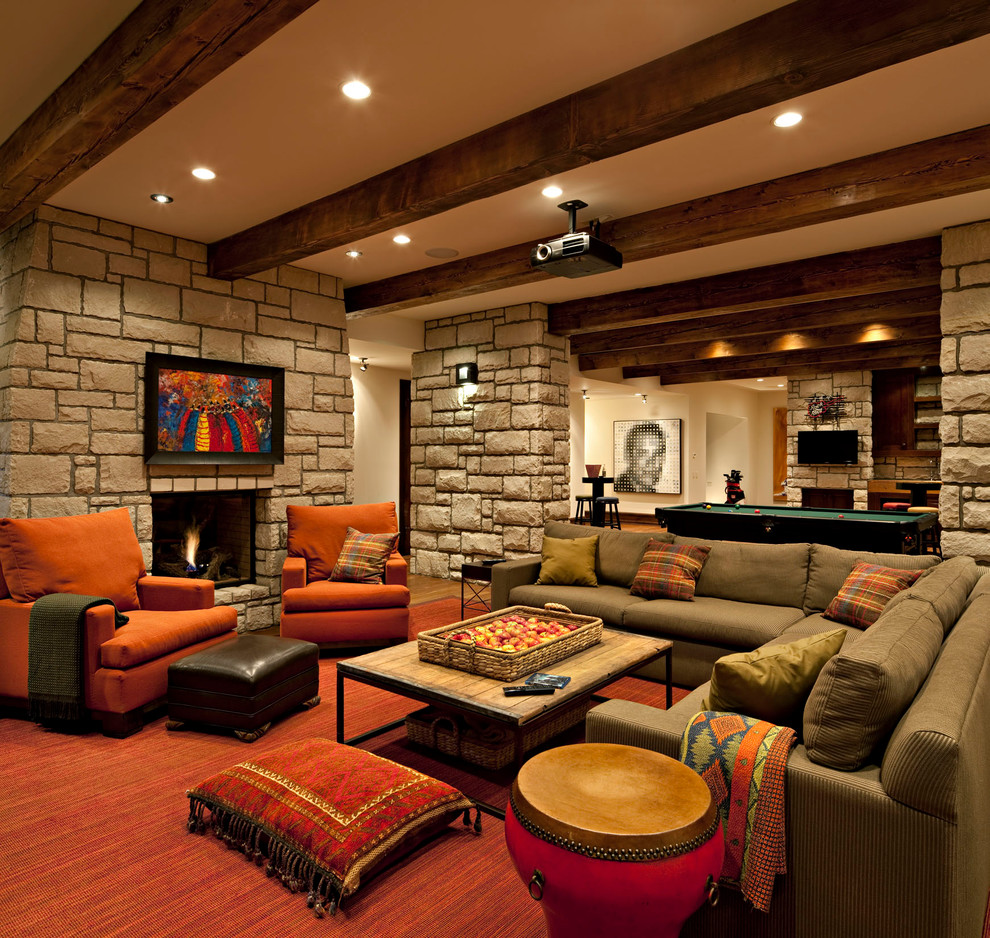 This is an example of a large country fully buried basement in Calgary with a stone fireplace surround, beige walls and a standard fireplace.