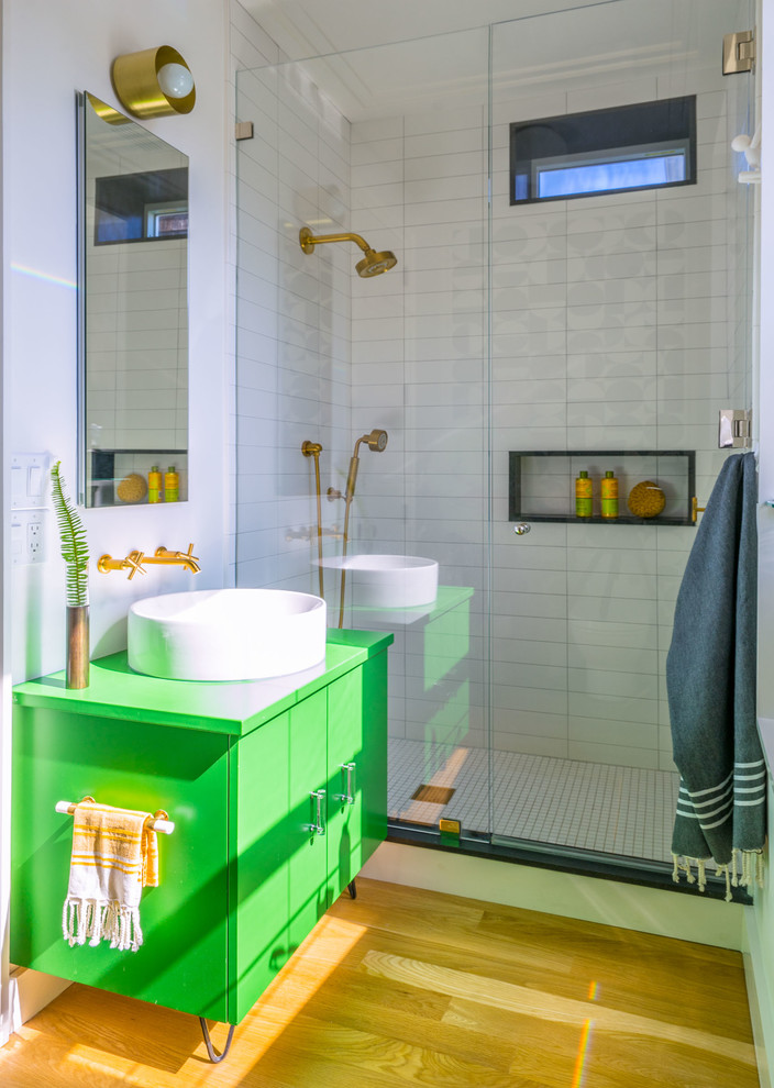 Inspiration for a contemporary 3/4 bathroom in Boston with flat-panel cabinets, green cabinets, an alcove shower, white tile, white walls, medium hardwood floors, a vessel sink, yellow floor and a hinged shower door.