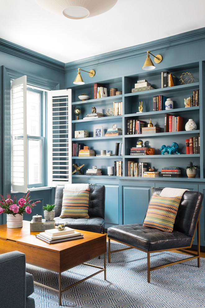 This is an example of a transitional living room in Boston with a library and blue walls.