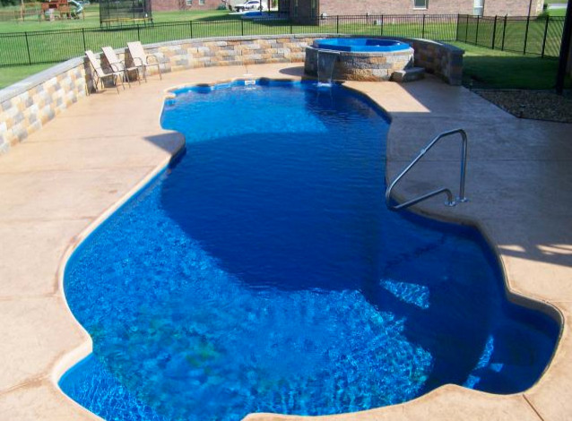 Example of a mid-sized backyard concrete and custom-shaped natural hot tub design in Cincinnati