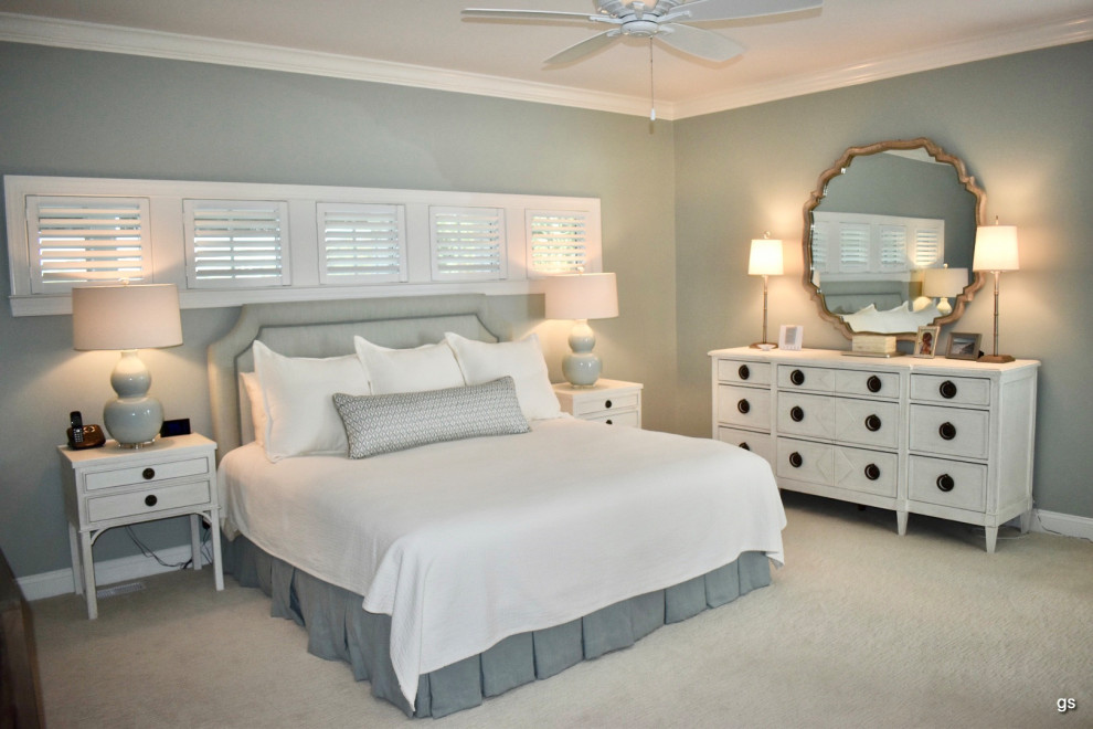 This is an example of a large coastal master bedroom in Charleston with blue walls, carpet and beige floors.