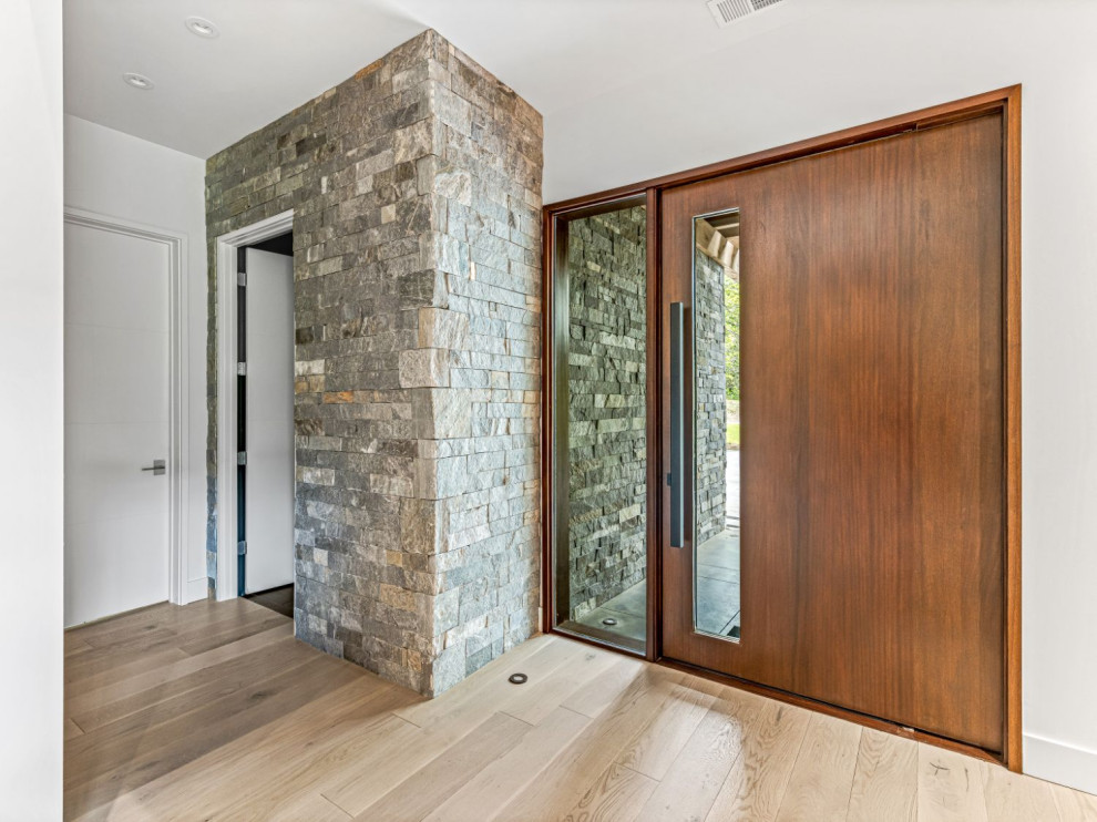 Example of a minimalist pivot front door design with a brown front door