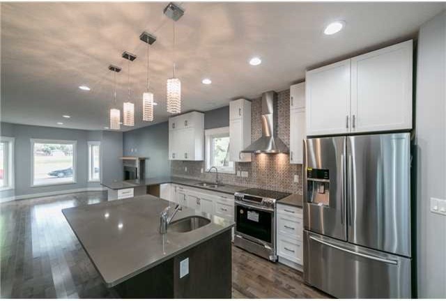 Inspiration for a mid-sized transitional l-shaped vinyl floor open concept kitchen remodel in Edmonton with shaker cabinets, white cabinets, multicolored backsplash, stainless steel appliances, an island, concrete countertops, mosaic tile backsplash and an undermount sink