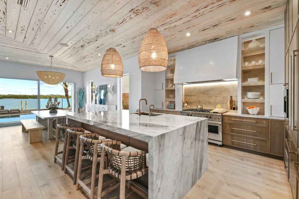 Photo of a medium sized beach style l-shaped open plan kitchen in Other with distressed cabinets, quartz worktops, integrated appliances and an island.