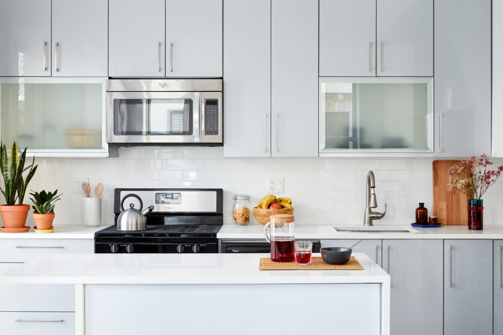 Esempio di una cucina minimal con lavello sottopiano, ante lisce, ante grigie, paraspruzzi bianco, elettrodomestici in acciaio inossidabile e top bianco