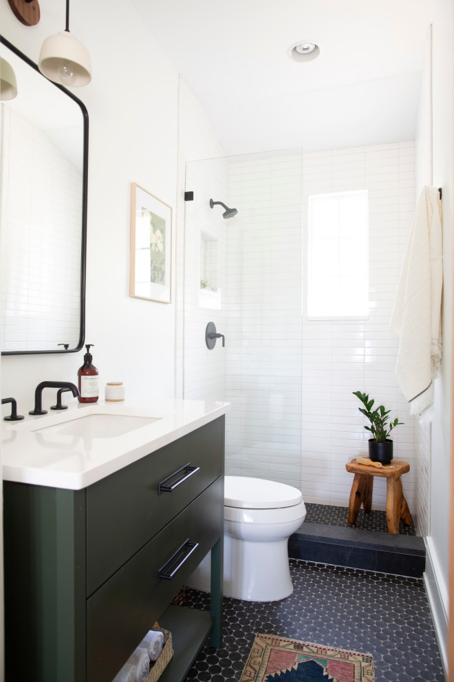 Свежая идея для дизайна: маленькая ванная комната в стиле неоклассика (современная классика) с плоскими фасадами, зелеными фасадами, унитазом-моноблоком, белой плиткой, цементной плиткой, белыми стенами, полом из керамогранита, душевой кабиной, врезной раковиной, столешницей из искусственного камня, черным полом, открытым душем, белой столешницей, нишей, тумбой под одну раковину и напольной тумбой для на участке и в саду - отличное фото интерьера