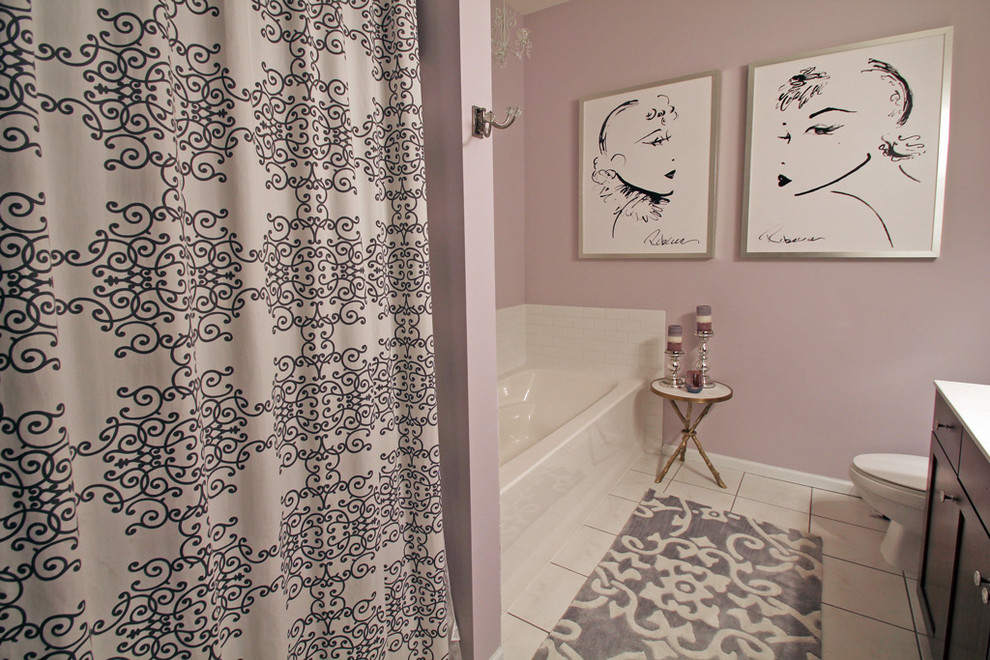 This is an example of a small transitional master bathroom in Minneapolis with an alcove tub, shaker cabinets, dark wood cabinets, an alcove shower, a one-piece toilet, white tile, ceramic tile, purple walls and ceramic floors.