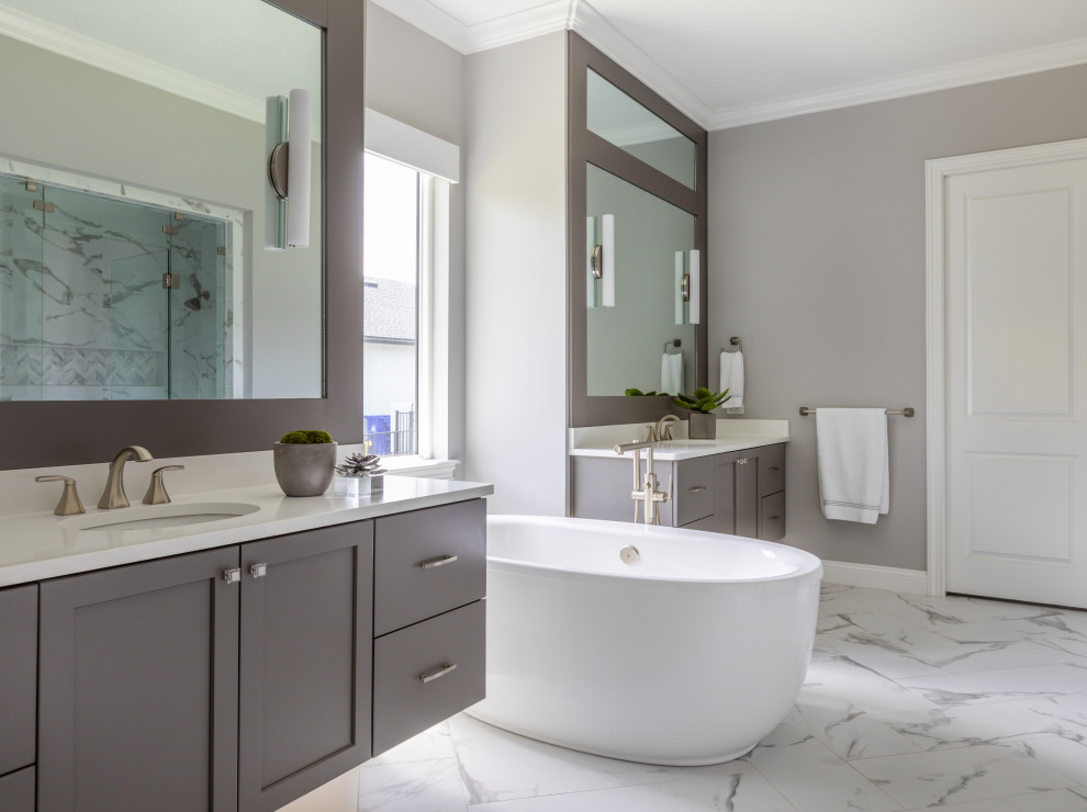 This is an example of a transitional bathroom in Jacksonville with shaker cabinets, grey cabinets, a freestanding tub, grey walls, an undermount sink, white floor, white benchtops, a double vanity and a floating vanity.