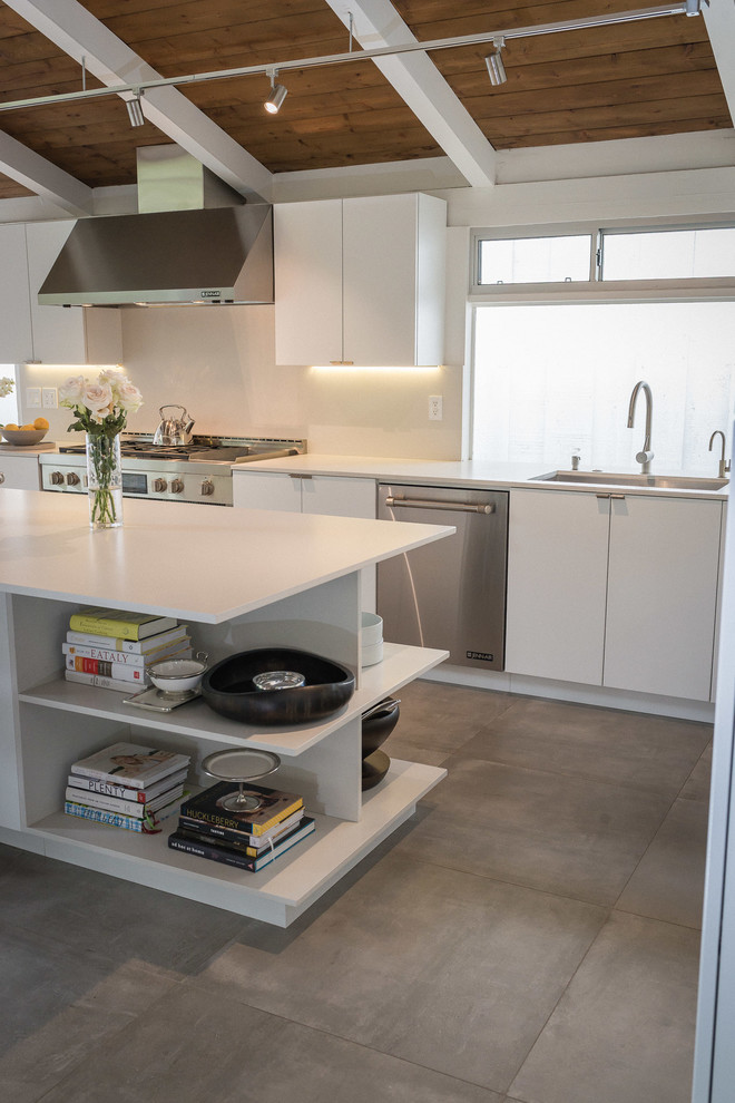 Design ideas for a large midcentury l-shaped eat-in kitchen in Los Angeles with an undermount sink, flat-panel cabinets, white cabinets, quartzite benchtops, white splashback, stone slab splashback, stainless steel appliances, slate floors and with island.