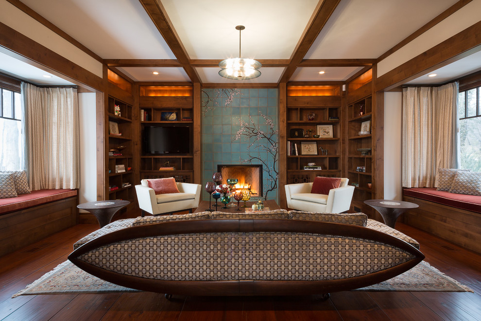 Photo of a mid-sized transitional enclosed living room in Chicago with a library, grey walls, medium hardwood floors, a standard fireplace, a tile fireplace surround and a built-in media wall.