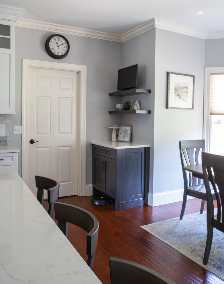 Inspiration for a transitional medium tone wood floor kitchen remodel with an undermount sink, shaker cabinets, quartz countertops, gray backsplash, porcelain backsplash, stainless steel appliances, an island and white countertops