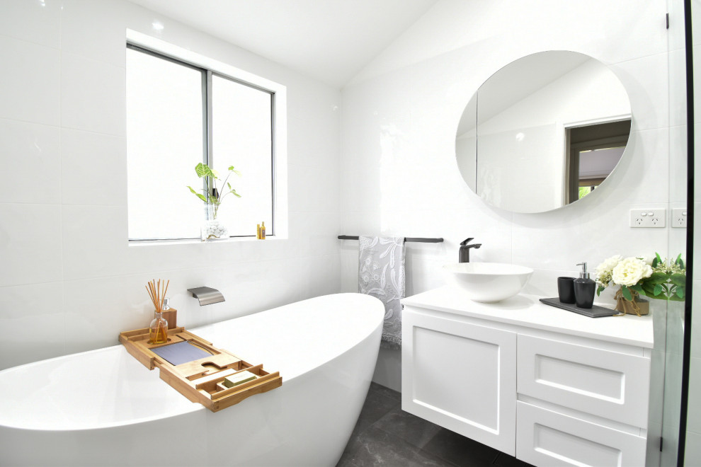 Modern inredning av ett en-suite badrum, med vita skåp, ett fristående badkar, en öppen dusch, vit kakel, keramikplattor, vita väggar, klinkergolv i keramik, bänkskiva i kvarts, grått golv och med dusch som är öppen