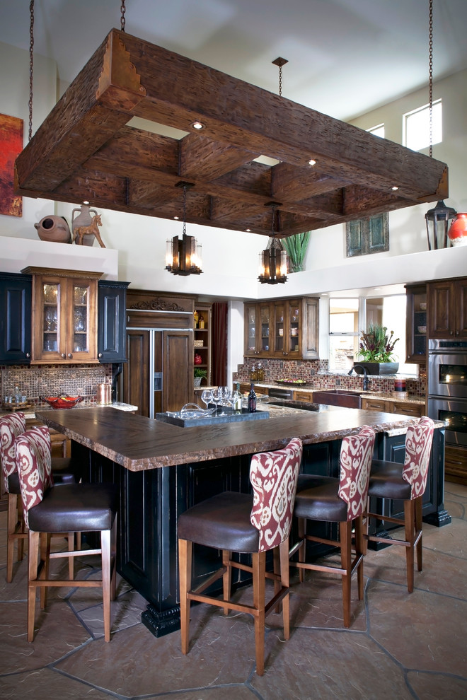Example of a large mountain style kitchen design in Phoenix with a farmhouse sink, glass tile backsplash, paneled appliances and an island