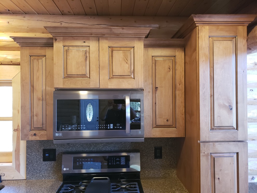 Example of a mountain style kitchen design in Phoenix with medium tone wood cabinets