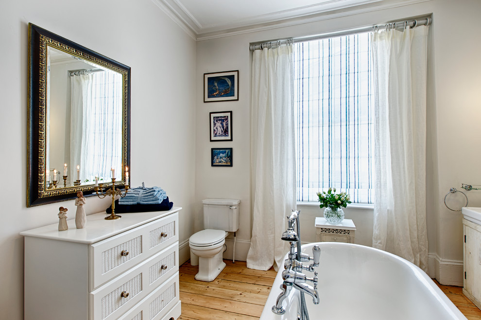 Design ideas for a large traditional kids bathroom in London with shaker cabinets, white cabinets, a freestanding tub, a shower/bathtub combo, a one-piece toilet, white walls and an integrated sink.