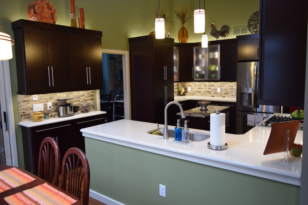 Kitchen - contemporary l-shaped vinyl floor and brown floor kitchen idea with an undermount sink, flat-panel cabinets, dark wood cabinets, quartz countertops, multicolored backsplash, glass sheet backsplash, stainless steel appliances and an island